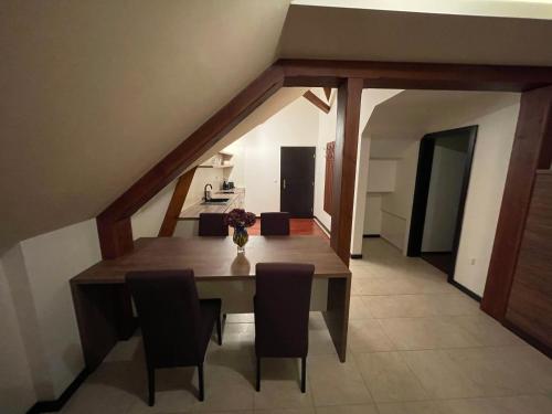 a dining room with a wooden table and chairs at RRR Apartmány 3 in Bojnice