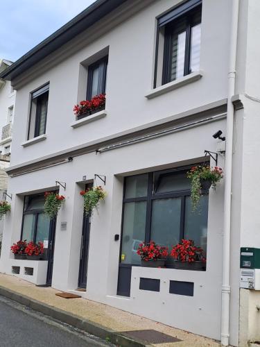 a white building with flowers in the windows at La Maison de Jeanne in Capvern