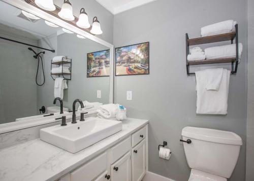 a bathroom with a sink and a toilet and a mirror at Sea Oats B106 by ALBVR - Great renovation and tons of space in this 2BR 2BA condo - Outdoor Pools, Pier, and Dedicated Beach Access in Gulf Shores