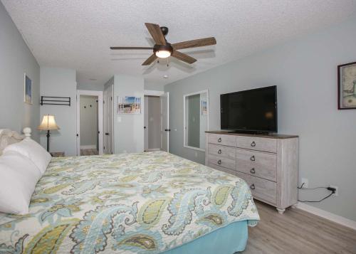 a bedroom with a bed and a flat screen tv at Sea Oats B106 by ALBVR - Great renovation and tons of space in this 2BR 2BA condo - Outdoor Pools, Pier, and Dedicated Beach Access in Gulf Shores