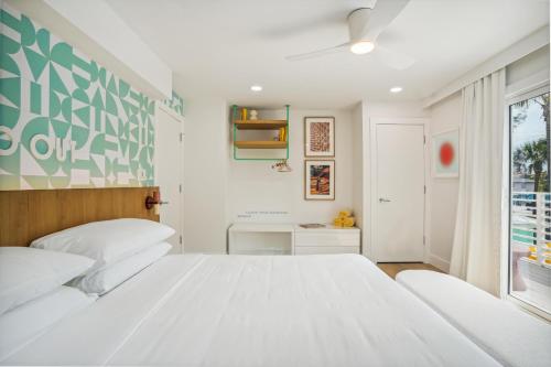 a bedroom with a large white bed and a window at Vitamin Sea in Holmes Beach