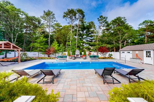 a patio with a swimming pool and chairs at Cape Castle in Mashpee