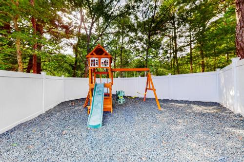 a playground with a slide and a house on it at Cape Castle in Mashpee