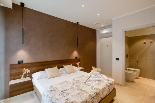 a bedroom with a large bed and a bathroom at Welcome Cagliari in Cagliari