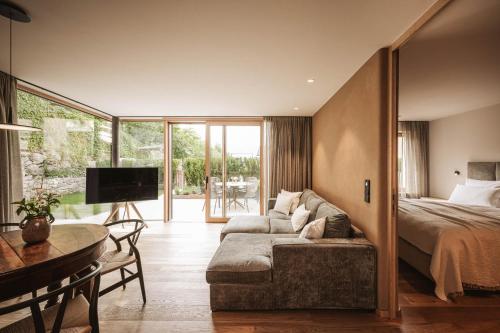 a bedroom with a bed and a couch and a table at Milla Apartments in Bressanone