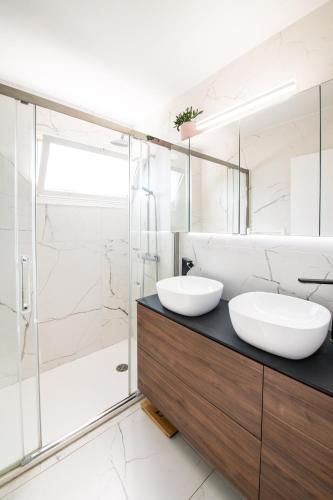 une salle de bain avec deux lavabos et une douche dans l'établissement Résidence méditerranée - Beachfront - Sun and Seaview - Pool - Private Parking, à Cagnes-sur-Mer