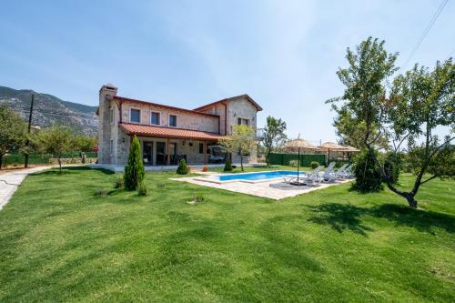 an exterior view of a house with a yard at Stone House Datça Blok-A in Datca