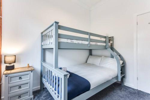 Robin Hood的住宿－Victorian Terrace, East Ardsley，带床头柜的客房内的白色双层床