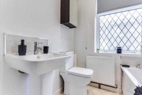a bathroom with a sink and a toilet and a window at Victorian Terrace, East Ardsley in Robin Hood