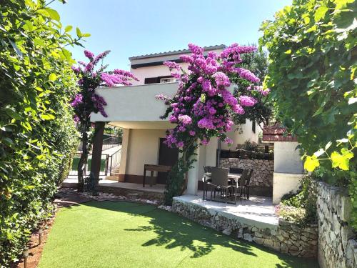 a garden with purple flowers hanging from a building at Villa Madu --- entire private villa with jacuzzi in Trogir