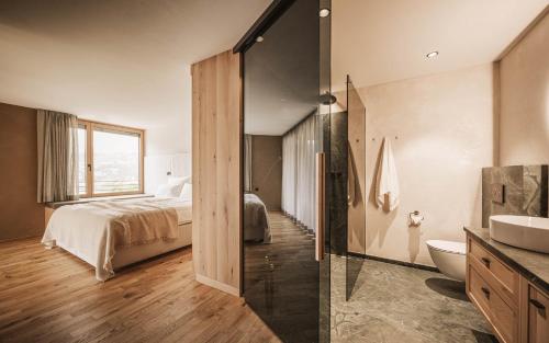 a bedroom with a bed and a bathroom with a sink at Milla Apartments in Bressanone