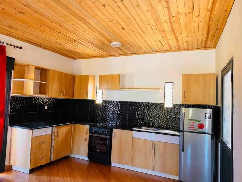 a kitchen with wooden cabinets and stainless steel appliances at Villa Myakatra in Hell-Ville