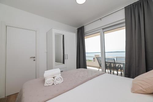 a bedroom with a large bed with a view of the ocean at Beachfront Apartments Tić with Seaview in Miletići
