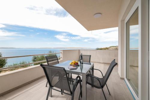 a table and chairs on a balcony with a view of the ocean at Beachfront Apartments Tić with Seaview in Miletići