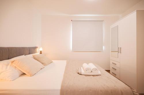 a bedroom with a bed with two towels on it at Beachfront Apartments Tić with Seaview in Miletići