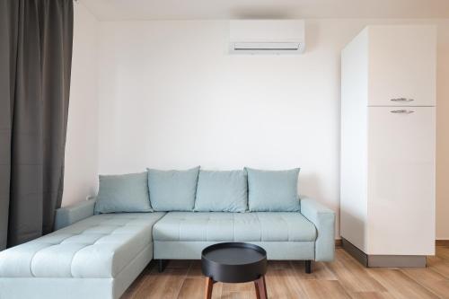 a living room with a blue couch and a table at Beachfront Apartments Tić with Seaview in Miletići