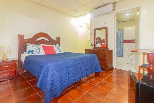 um quarto com uma cama e uma casa de banho com um espelho. em VBermor Hotel em Santo Domingo