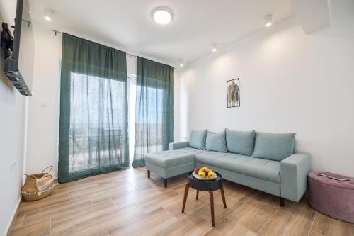 a living room with a blue couch and a table at Beachfront Apartments Tić with Seaview in Miletići