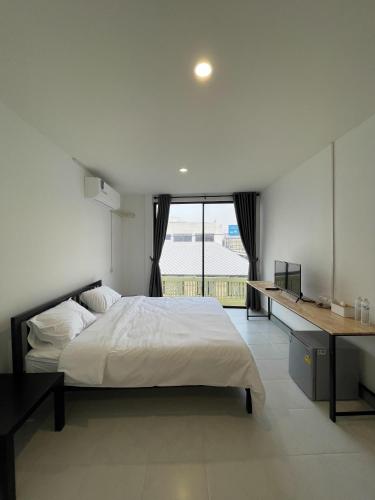 a bedroom with a bed and a desk and a window at GO INN HuaHin โกอินน์ หัวหิน in Hua Hin