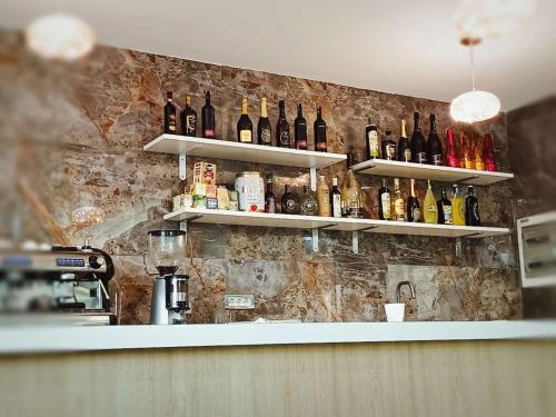 un bar con botellas de vino en la pared en ANMAN HHBB tourism & business rooms, en Padua