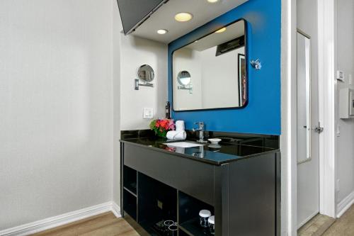 a bathroom with a black vanity and a mirror at Hotel Griffon in San Francisco