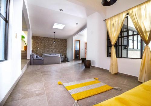 un soggiorno con tappeto giallo sul pavimento di Casa InHome, your home at Oaxaca a Città di Oaxaca
