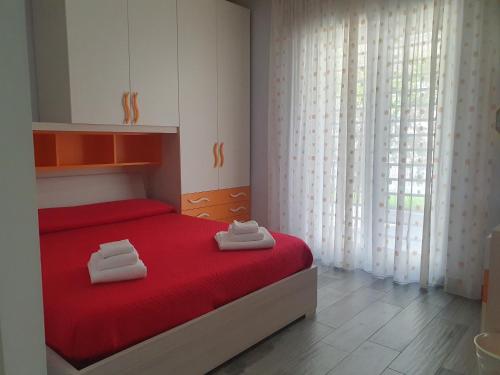 a bedroom with a red bed with two towels on it at Villa Giulia in Pozzuoli