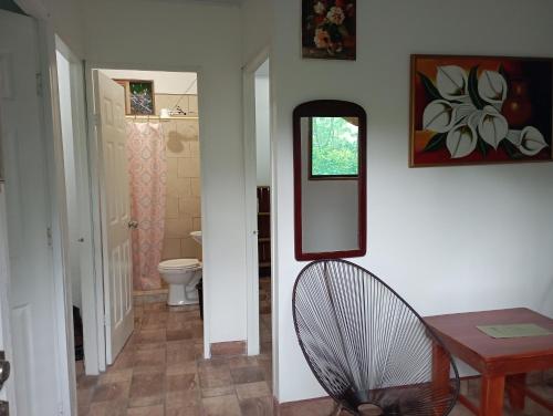 a hallway with a mirror and a chair in a room at Finca Los 3 Laureles Nicaragua AgroEcolodge in San Ramón