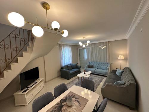 a living room with couches and a staircase at Side Holiday House in Side