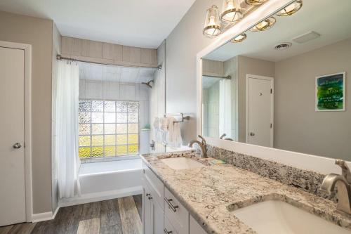 ein Badezimmer mit Waschbecken und großem Spiegel in der Unterkunft Litchfield Country Club Cottage 4BR 4BA Retreat in Pawleys Island