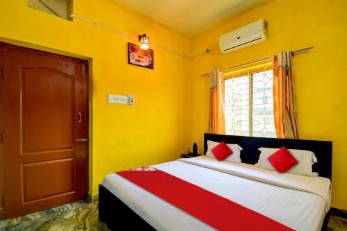 - une chambre avec un lit aux murs jaunes et une fenêtre dans l'établissement OYO Flagship Hotel Elite Inn, à Bhubaneswar