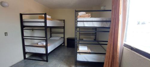 a room with four bunk beds in a room with a window at Residencias Señorial in Mexico City