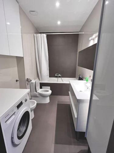 a bathroom with a washing machine and a toilet at Riga Modern Apartment in Rīga