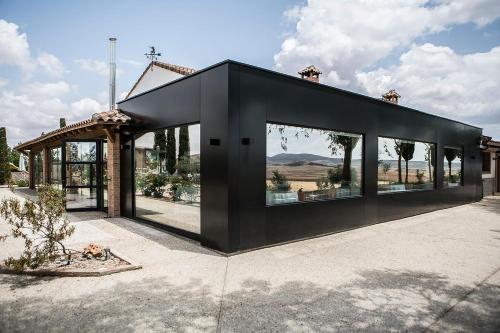 una casa negra con grandes ventanas en Hotel El Coto De Quevedo, en Torre de Juan Abad