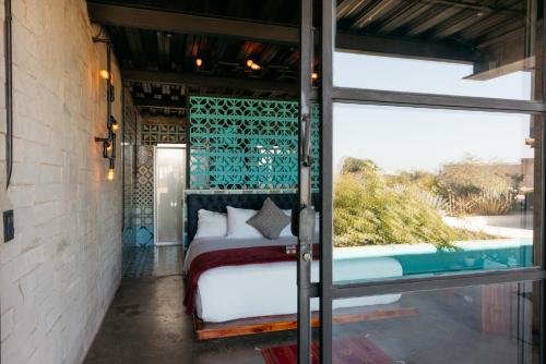 a bedroom with a bed and a pool at Hotel Los Amantes Valle de Guadalupe in Valle de Guadalupe