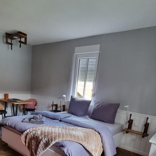 a bedroom with two beds and a table and a window at FeWo zur alten Tischlerei in Herzberg am Harz