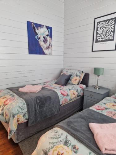 a bedroom with two beds and a painting on the wall at Kozy Kabin in Waterford