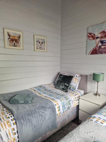 a bedroom with two beds and two pictures of cats at Kozy Kabin in Waterford