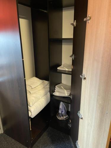 a locker room with a closet with towels and a pair of shoes at Studio Rm Vâlcea in Râmnicu Vâlcea