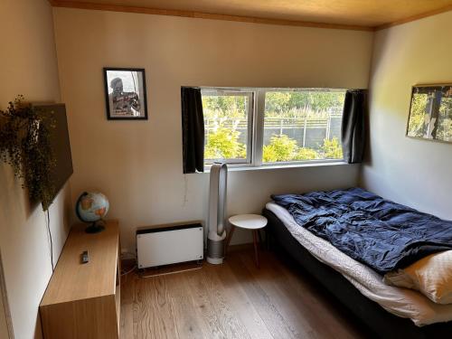 a bedroom with a bed and a window at Northstay - House of Northern Lights in Tromsø