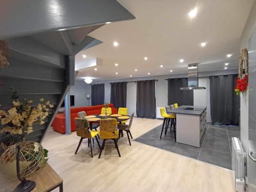 a living room with a table and yellow chairs at Le palais duplex in Autun