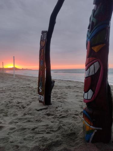 a pair of skis standing on the beach at sunset at La palmera zorritos in Tumbes