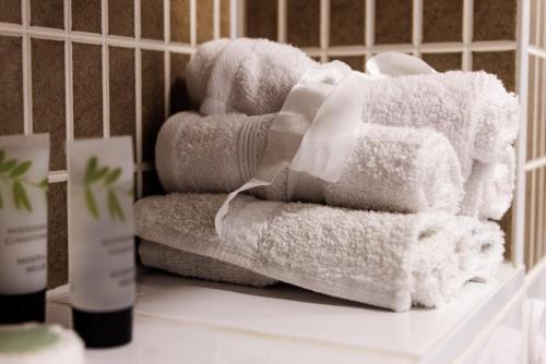 una pila de toallas sentadas en el mostrador del baño en Comfortable 4-Bedroom Home in Aylesbury Ideal for Contractors Professionals or Larger Families en Aylesbury