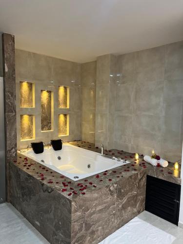 La salle de bains est pourvue d'une grande baignoire avec des bougies. dans l'établissement Hotel el tamaco, à Ocaña