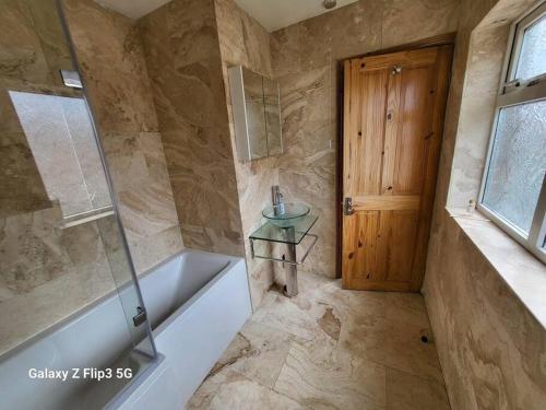 a bathroom with a tub and a sink and a shower at APNI HOMES! in Birstall