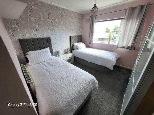 um pequeno quarto com 2 camas e uma janela em APNI HOMES! em Birstall