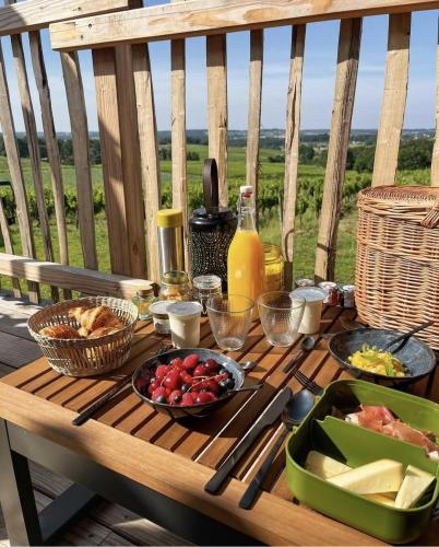 a picnic table with food and drinks on a deck at Le Domaine de La Tour des Vents in Bergerac