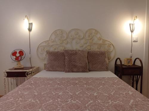 a bedroom with a bed with a white headboard and two lamps at Gerês e Cabreira - Romoa Vintage Guest House in Vieira do Minho