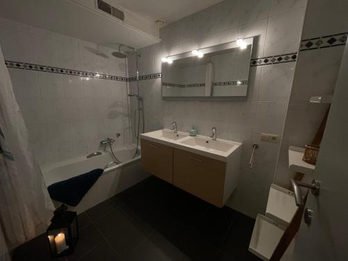 a bathroom with a sink and a tub and a mirror at Dreamland Resort in Zaventem