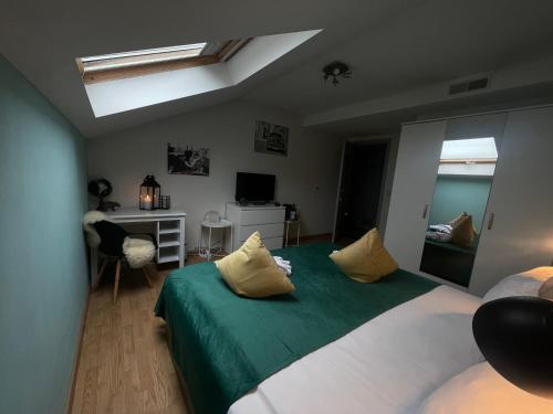 a bedroom with a green and white bed and a desk at Dreamland Resort in Zaventem